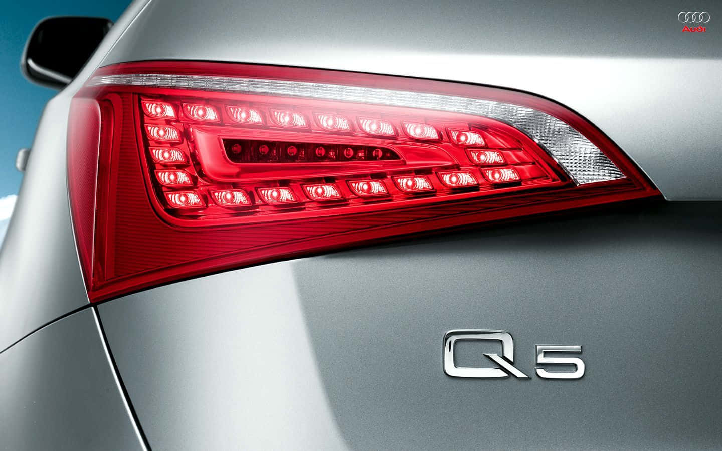 Audi Q5 桌布 壁紙 — 時尚銀色Audi Q5的現代紅色LED尾燈在清澈藍天下的特寫。