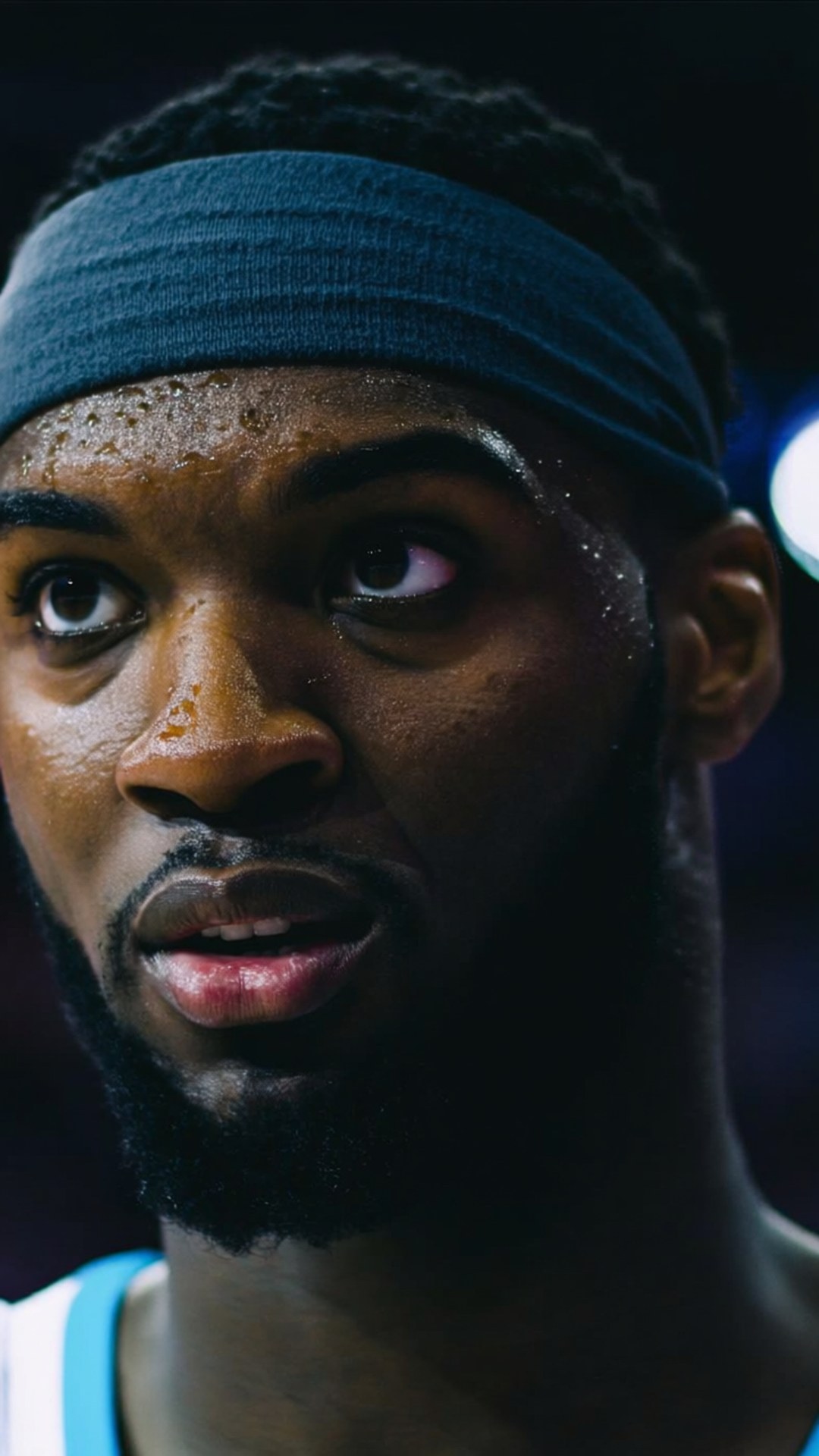 Focused Gaze 壁紙 — 近距離拍攝一名汗流浹背的籃球運動員，戴著深藍色頭帶，在場館燈光下眼神專注而強烈。