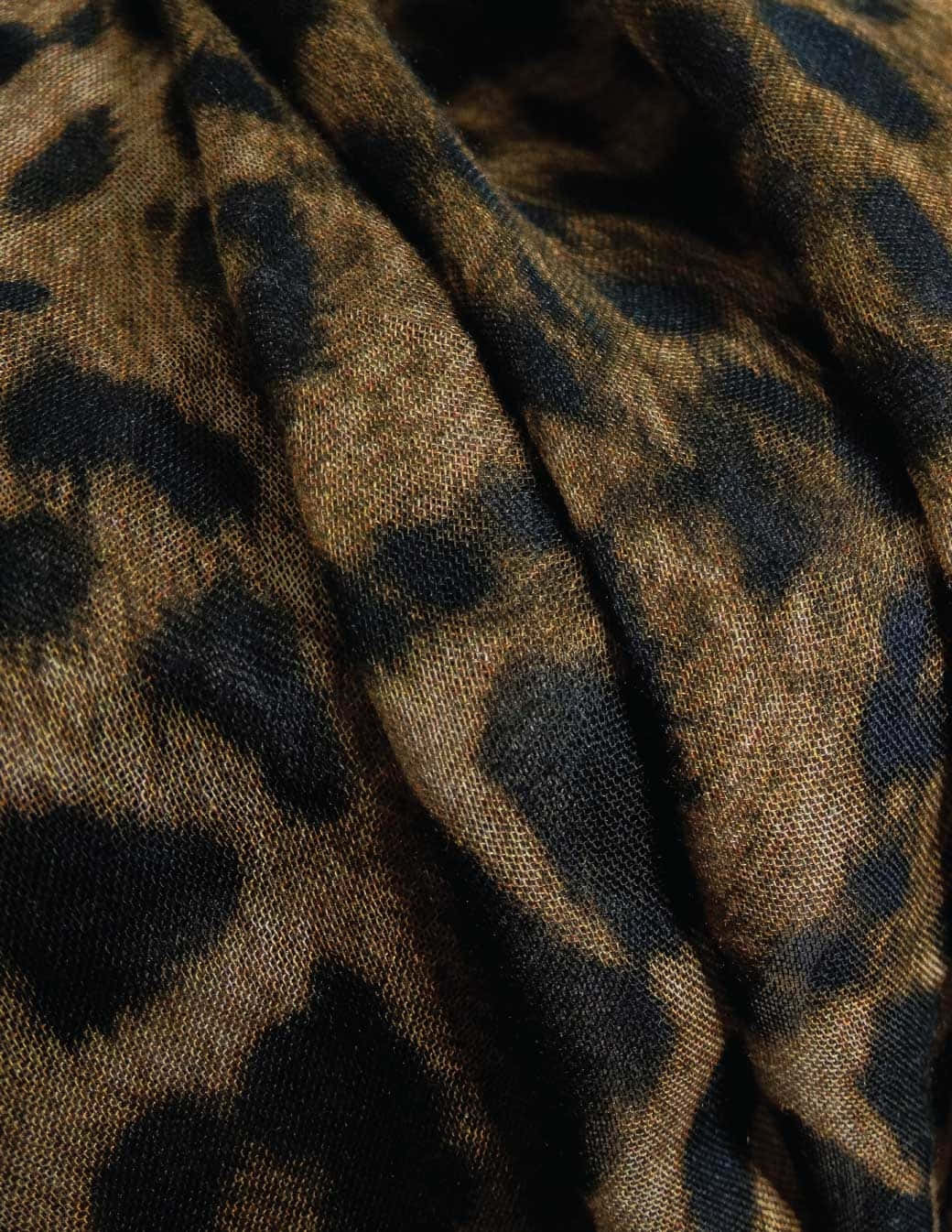 壁紙 — 帶有大地棕色和黑色大膽豹紋圖案的紋理布料的特寫。
