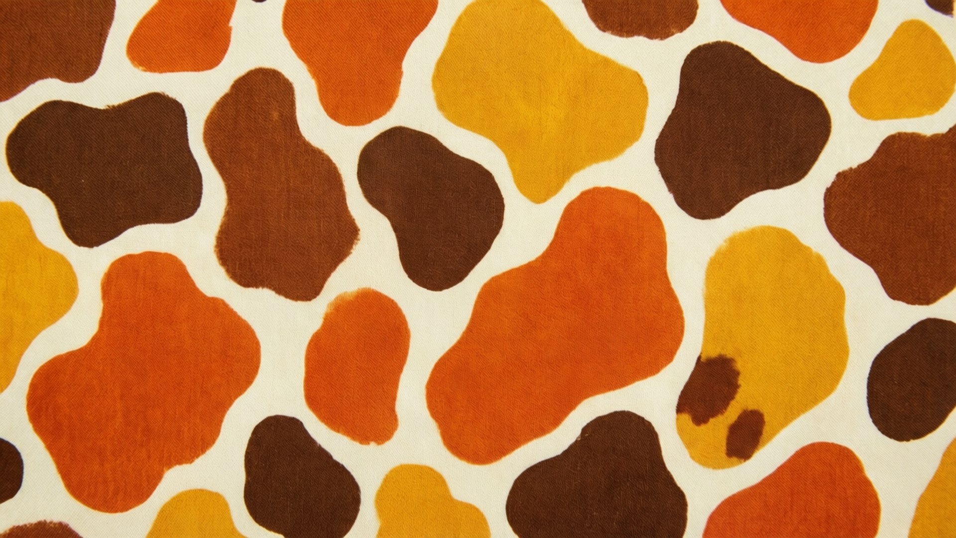 Autumn Cow Print 壁紙 — 奶油色背景上帶有不規則棕色、橙色和黃色斑塊的紋理織物特寫。