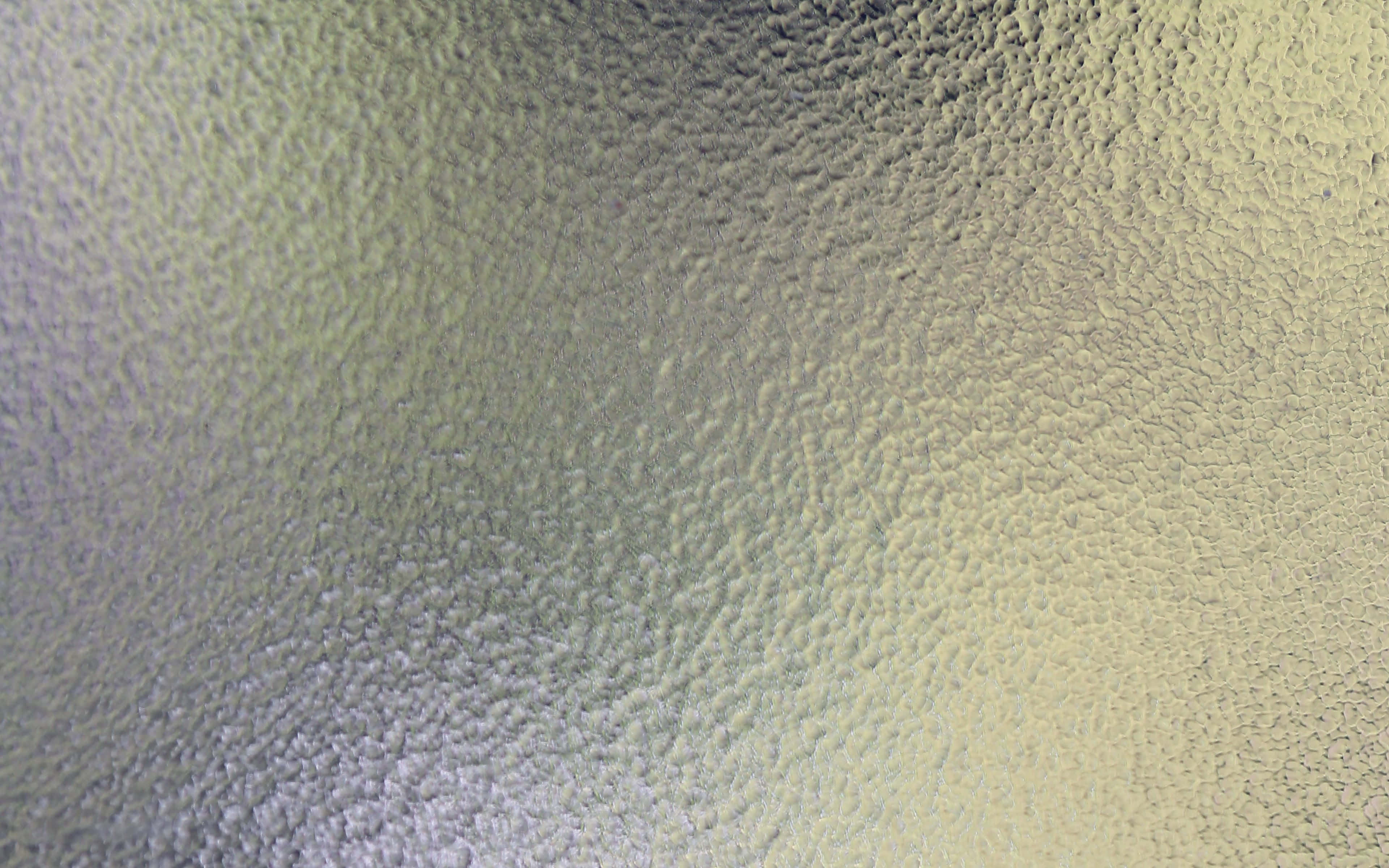 Glass Texture 桌布 壁紙 — 一個紋理表面的特寫，帶有從冷灰色到暖米色的漸變，呈現細小的卵石圖案。