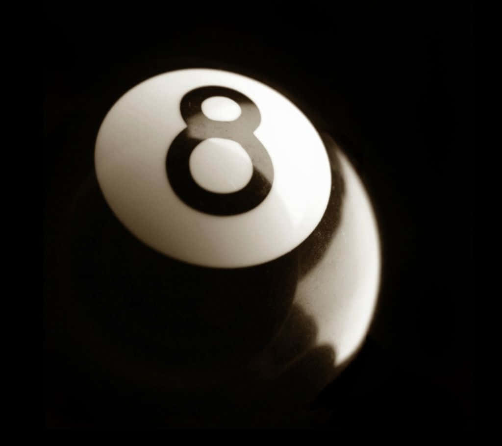  壁紙 — 白色撞球8號球在黑暗背景中亮起的特寫。