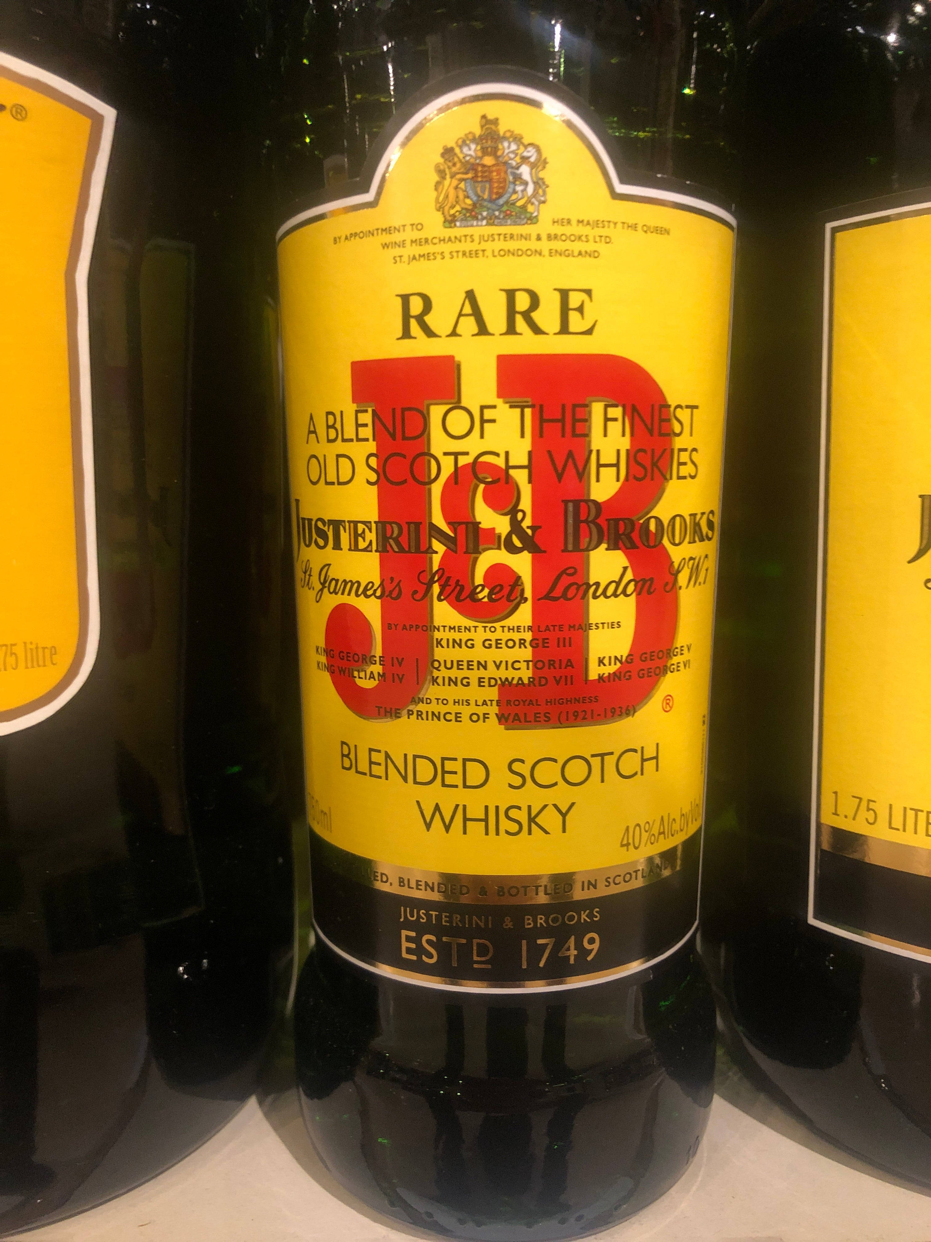 drinks 桌布 壁紙 — Justerini & Brooks Rare Blended Scotch Whisky 酒瓶特寫，黃色標籤，帶有皇家徽章和復古文字。