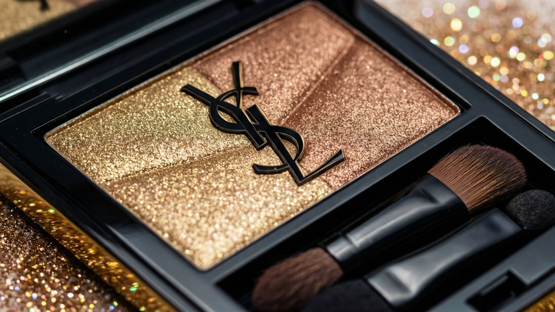 YSL Glitter Eyeshadow 壁紙 — YSL閃粉眼影盤的特寫，帶有金色古銅色調和黑色標誌，伴隨著刷子放在閃閃發光的金色背景上。