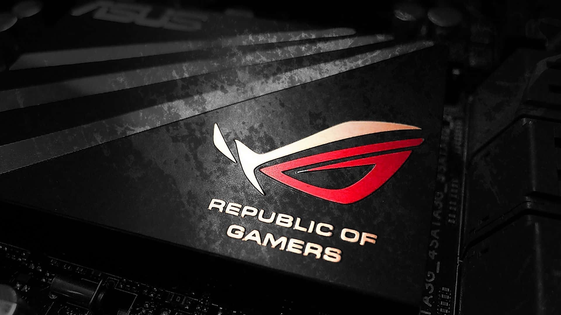 玩家共和國 桌布 壁紙 — ASUS ROG Republic of Gamers 標誌在帶有紋理的黑色遊戲主機板上發出紅色和白色光芒的特寫。