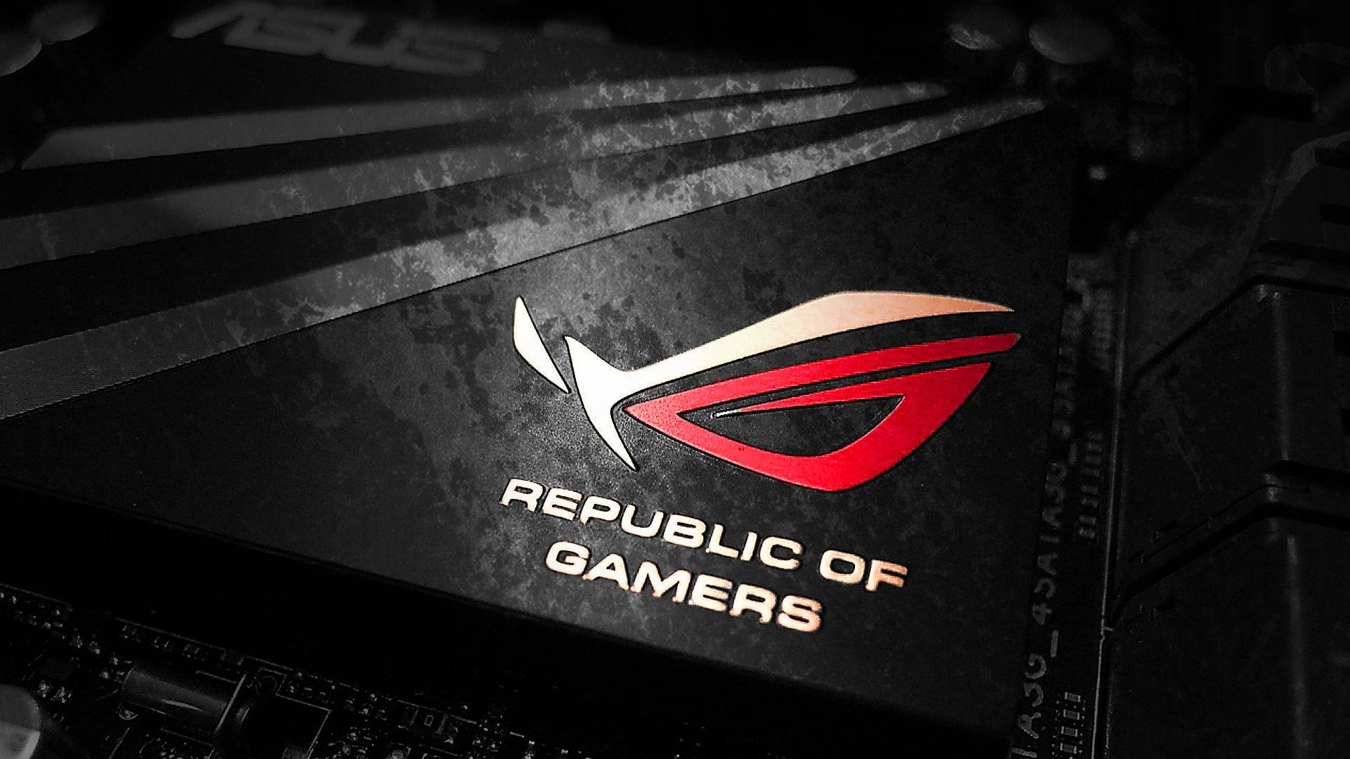 華碩 ROG 桌布 壁紙 — ASUS ROG Republic of Gamers 標誌特寫，位於黑色紋理主機板上，帶有紅色和銀色點綴。