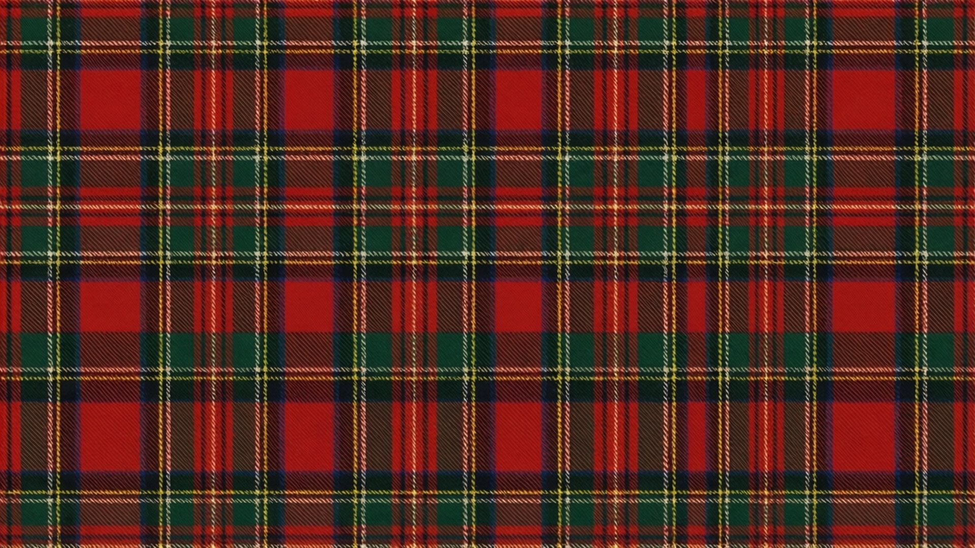 Christmas Tartan Plaid 壁紙 — 經典蘇格蘭格紋布料的特寫，大膽的紅、綠、黃色條紋形成重複的幾何圖案。