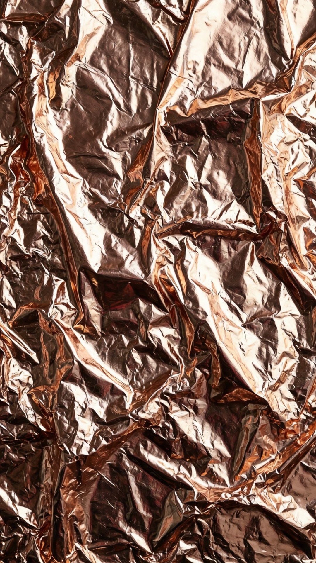 Crumpled Rose Gold Foil 壁紙 — 皺巴巴的玫瑰金箔特寫，帶有深褶皺和明亮的高光反射光線。