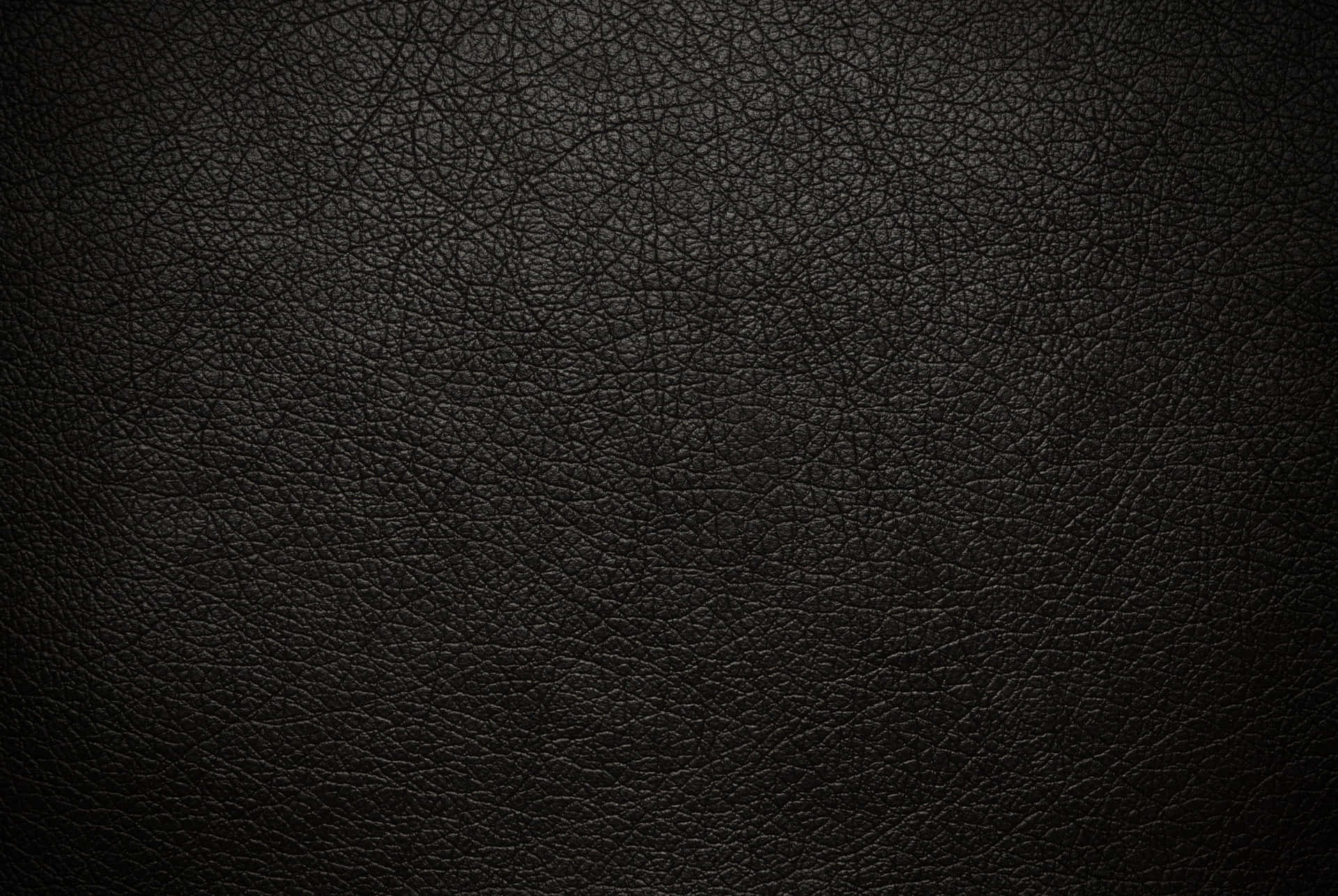 帶有自然紋理圖案的深色紋理黑色皮革表面。 — Stitch 壁紙