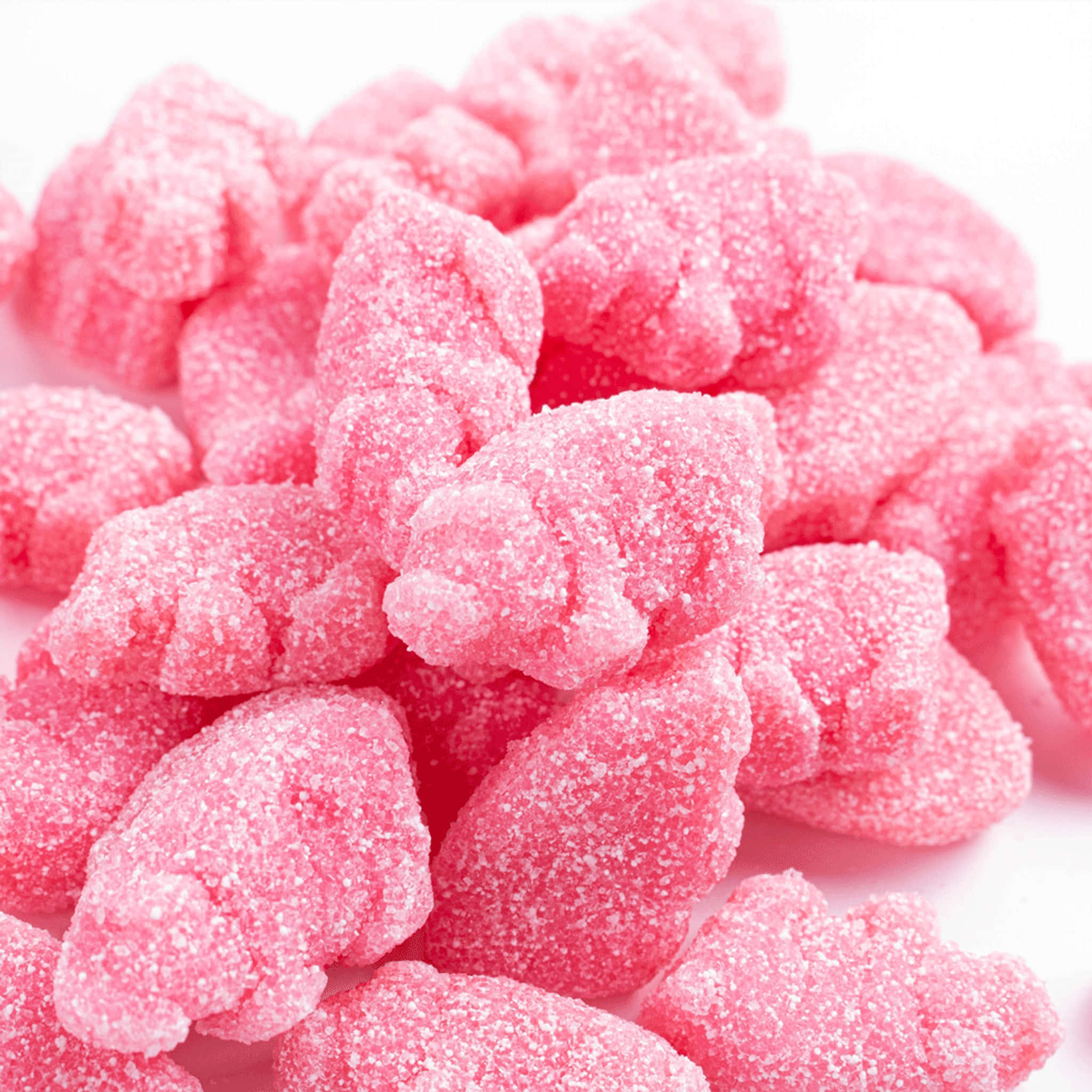 Pink Candy 桌布 壁紙 — 一個特寫鏡頭，閃閃發光的粉紅色糖衣軟糖堆疊在白色背景上。