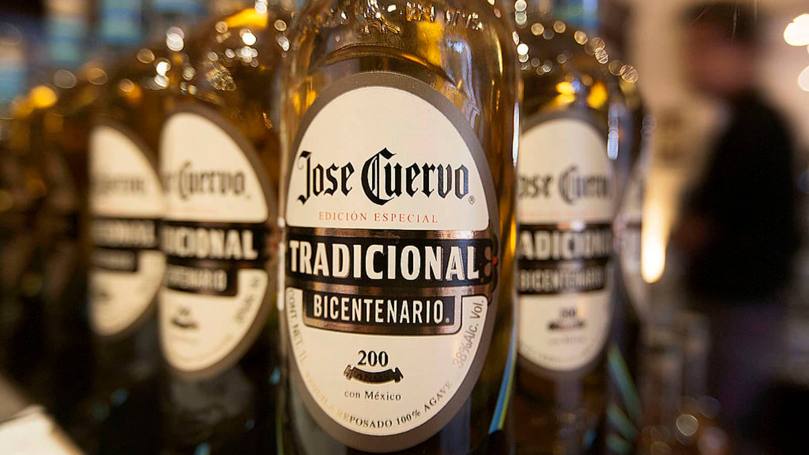 bottle 桌布 壁紙 — Jose Cuervo Tradicional Bicentenario 酒瓶的特寫，背景為散景效果，光線溫暖。