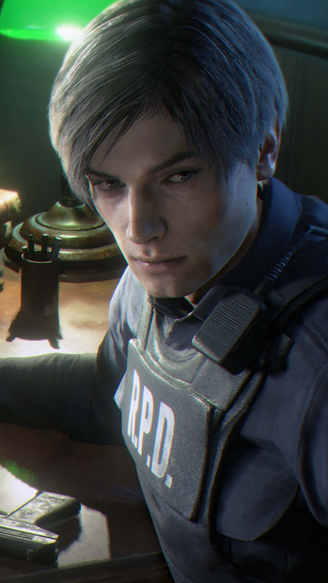  壁紙 — Leon S. Kennedy 身穿R.P.D.背心，在昏暗的房間裡專注地看著一張放有手槍和檯燈的書桌的特寫。