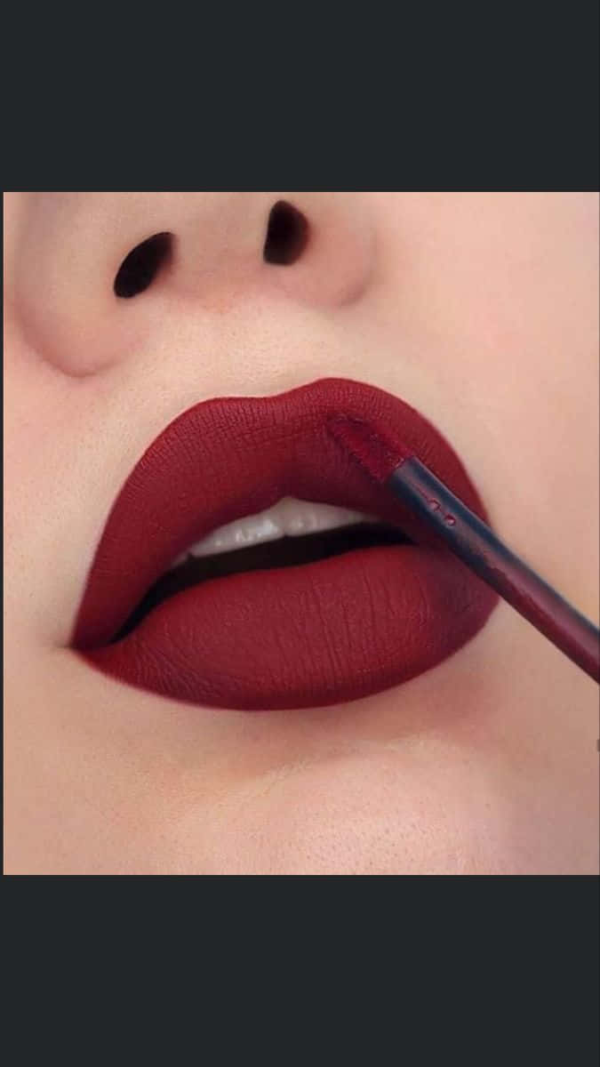 lipstick 桌布 壁紙 — 嘴唇特寫，用精準刷子塗上濃郁的啞光酒紅色唇膏。