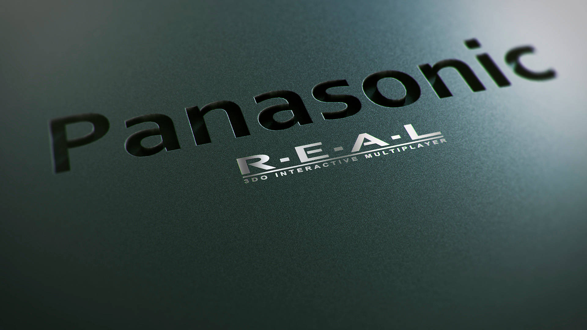 Panasonic 桌布 壁紙 — Panasonic R-E-A-L 3DO Interactive Multiplayer 標誌特寫，位於帶紋理的深綠色表面上，光線柔和。