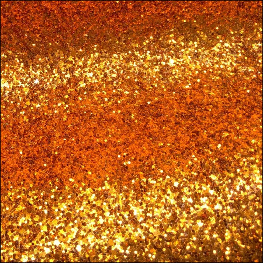 Orange Glitter 桌布 壁紙 — 金色和橙色閃粉的特寫，營造出閃爍的紋理表面，帶有耀眼的高光。