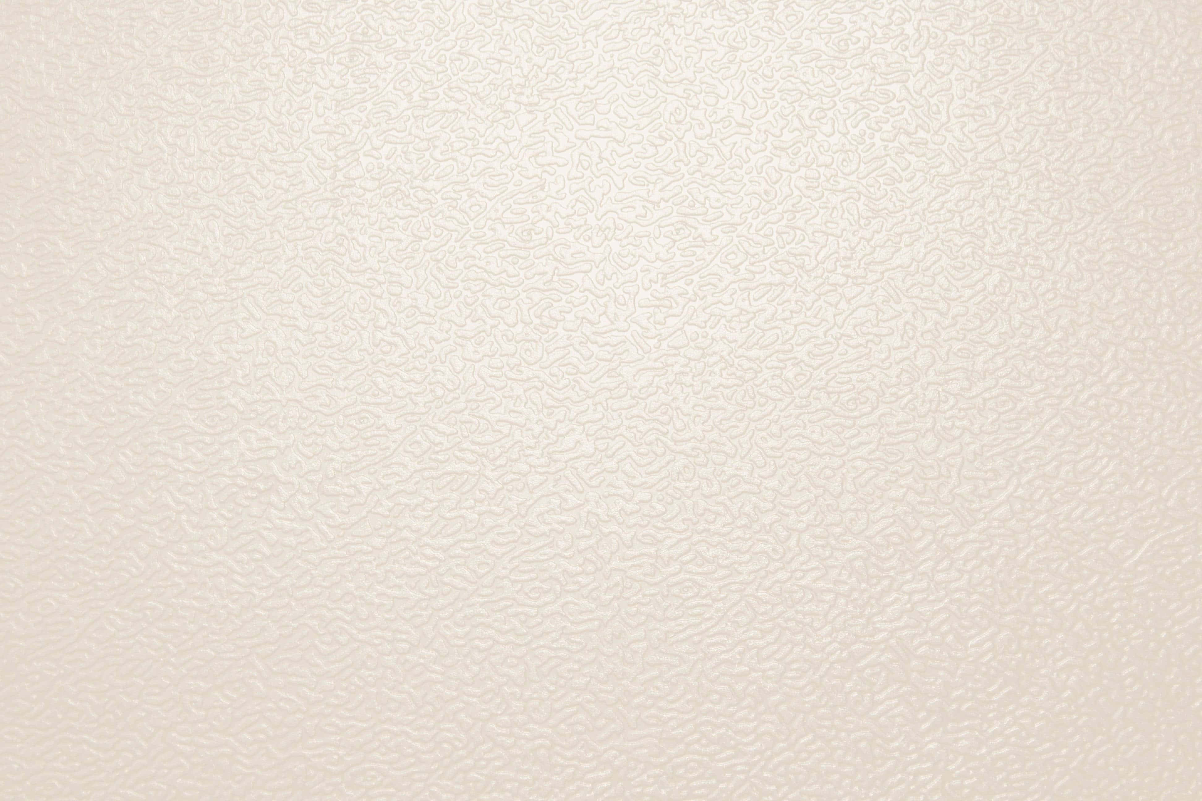 Cream Color 桌布 壁紙 — 柔和燈光下，光滑米白色紋理壁紙的特寫，帶有微妙的漩渦壓花圖案。