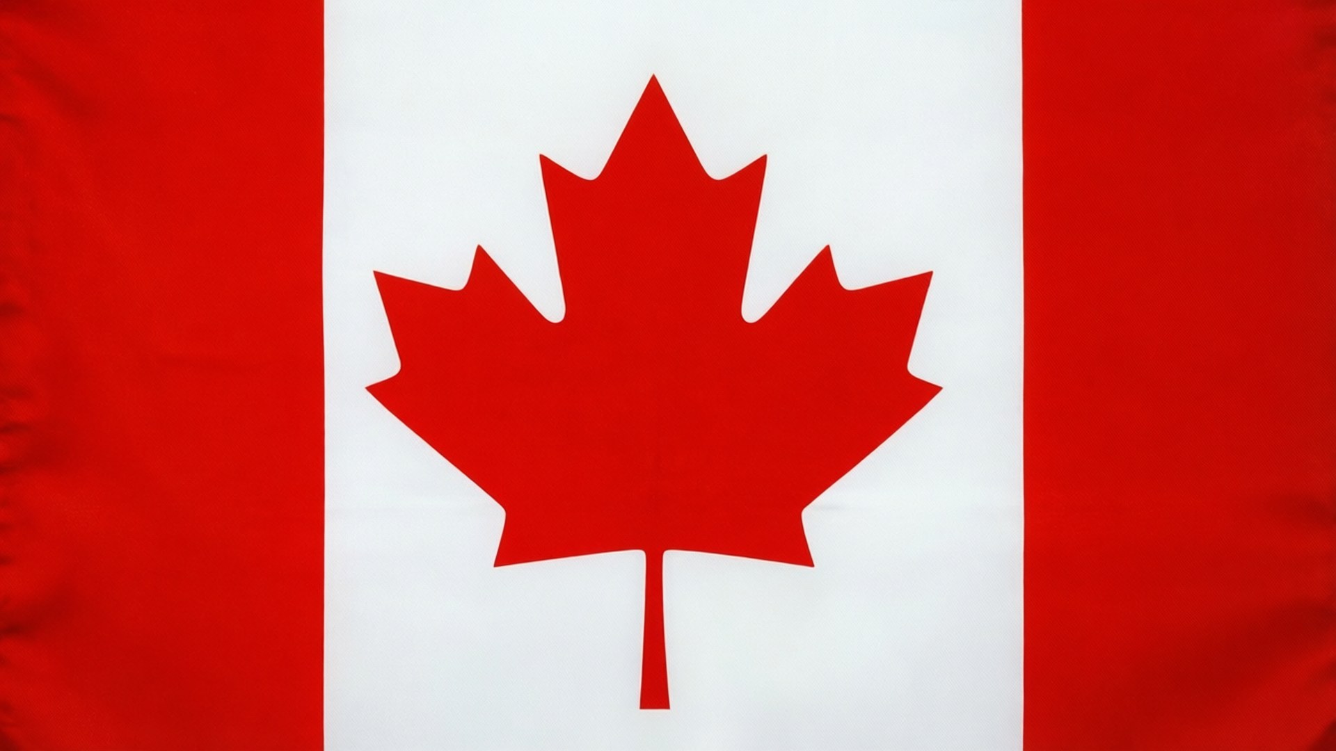 Minimalist Maple Leaf 壁紙 — 加拿大國旗的特寫，顯示一個大膽的紅色楓葉居中於白色區域，兩側有紅色垂直條紋。