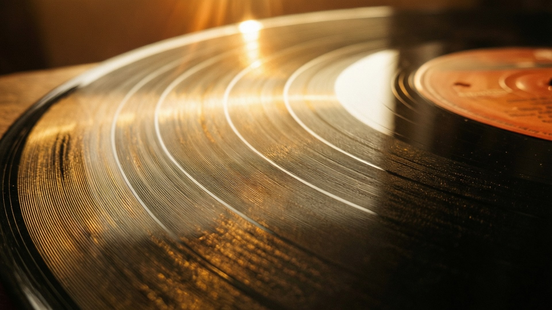 vinyl 桌布 壁紙 — 黑膠唱片的特寫，沐浴在溫暖的金色光線中，突顯其溝槽和反光表面。