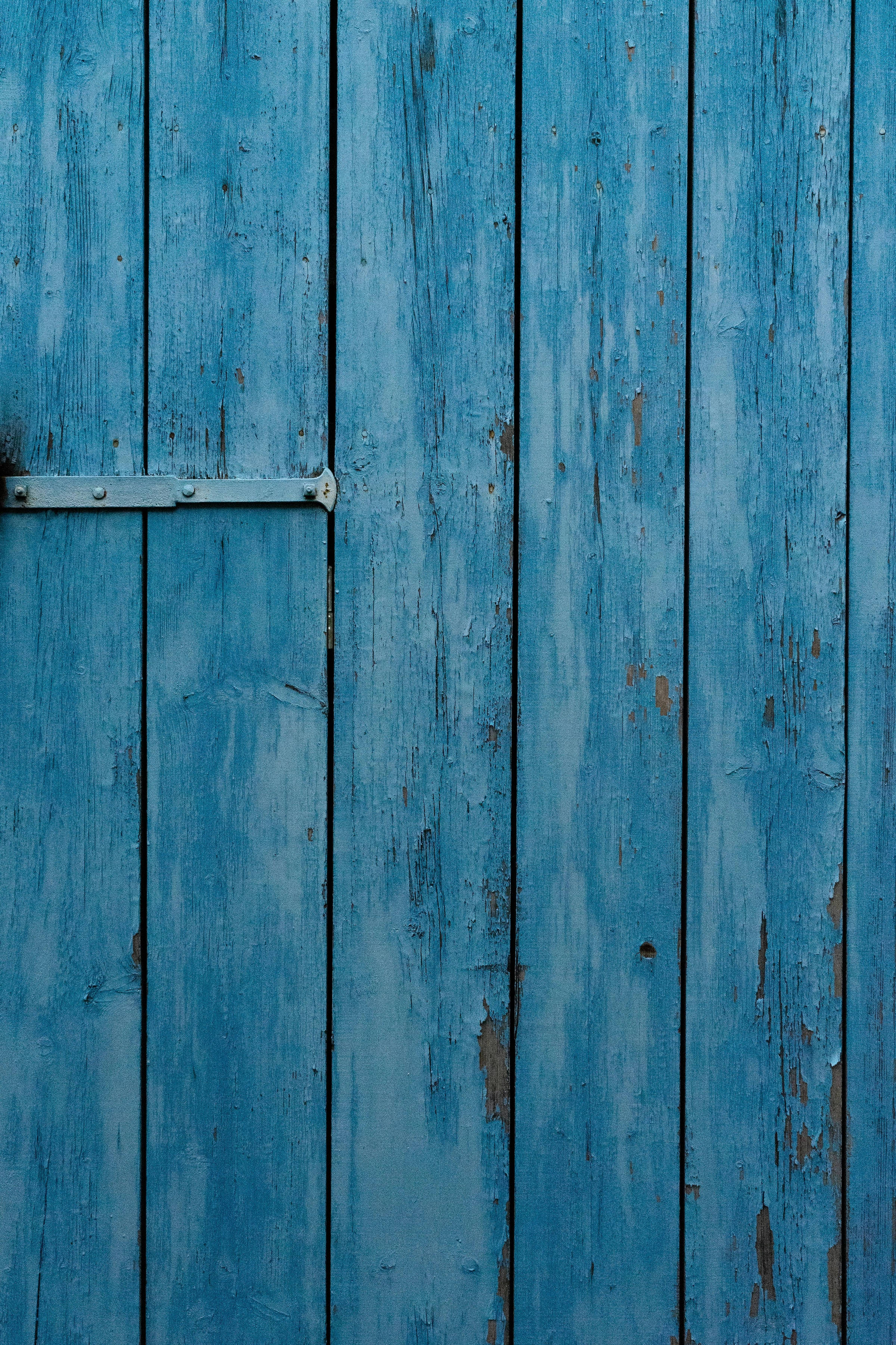 Aesthetic Blue 桌布 壁紙 —  weathered blue wooden planks with peeling paint and a metal hinge的特寫。