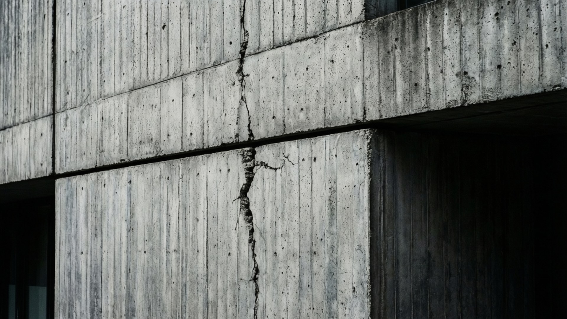 Gray Concrete Texture 壁紙 — 風化混凝土板的特寫，帶有明顯的垂直裂縫穿過它們。