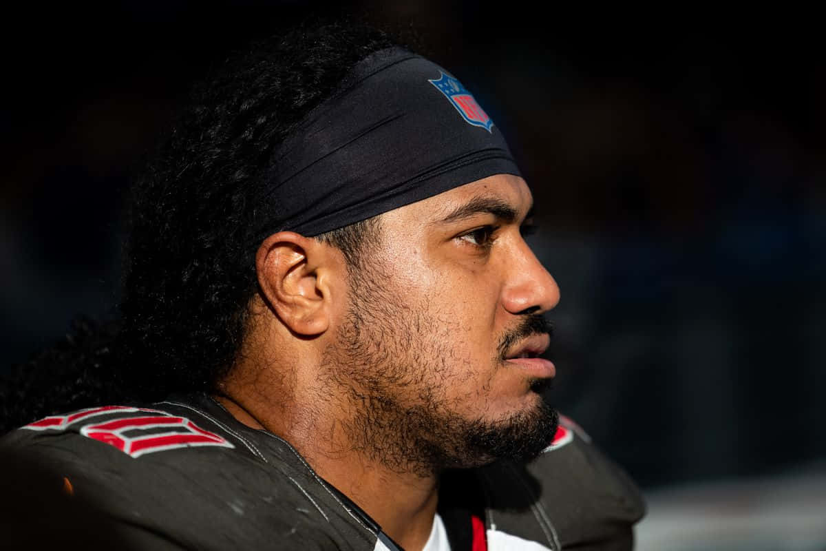  壁紙 — 專注的NFL美式足球員身穿制服、戴著頭帶的近距離肖像，專注地向前看。