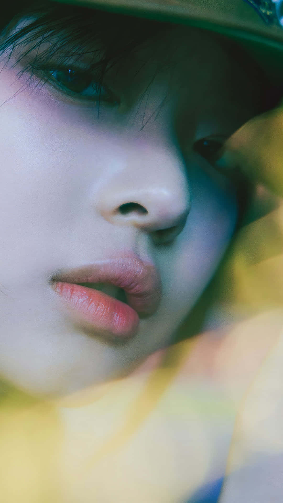  壁紙 — 一個人戴著帽子的特寫肖像，在充滿氛圍的霓虹燈光下，背景柔和模糊。