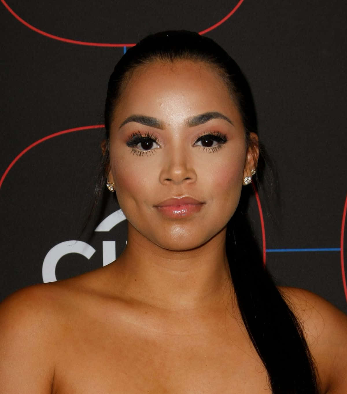 Lauren London 桌布 壁紙 — 一位長髮深色、妝容華麗的女性的特寫肖像，背景為深色，帶有紅色和白色的幾何線條。