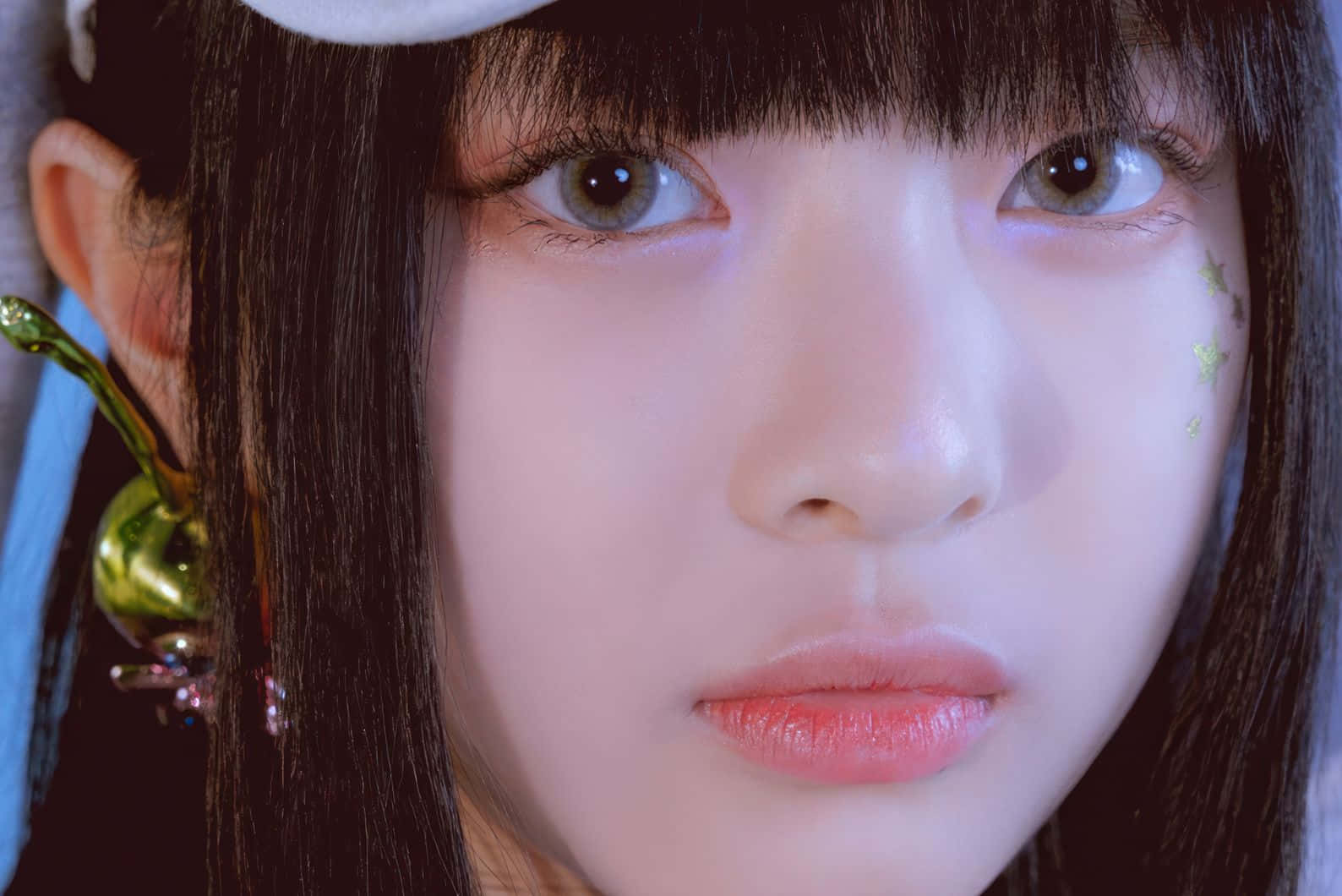  壁紙 — 年輕黑髮女子在柔和粉紅燈光下臉頰上有星形亮粉的特寫肖像。