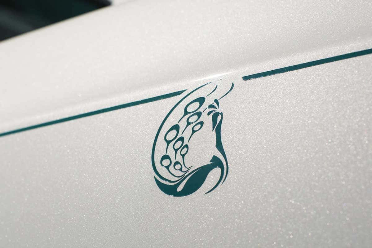 Rolls Royce Phantom Drophead Coupe 桌布 壁紙 — 白色汽車紋理表面上帶有細青綠色線條的青綠色部落風格標誌特寫。