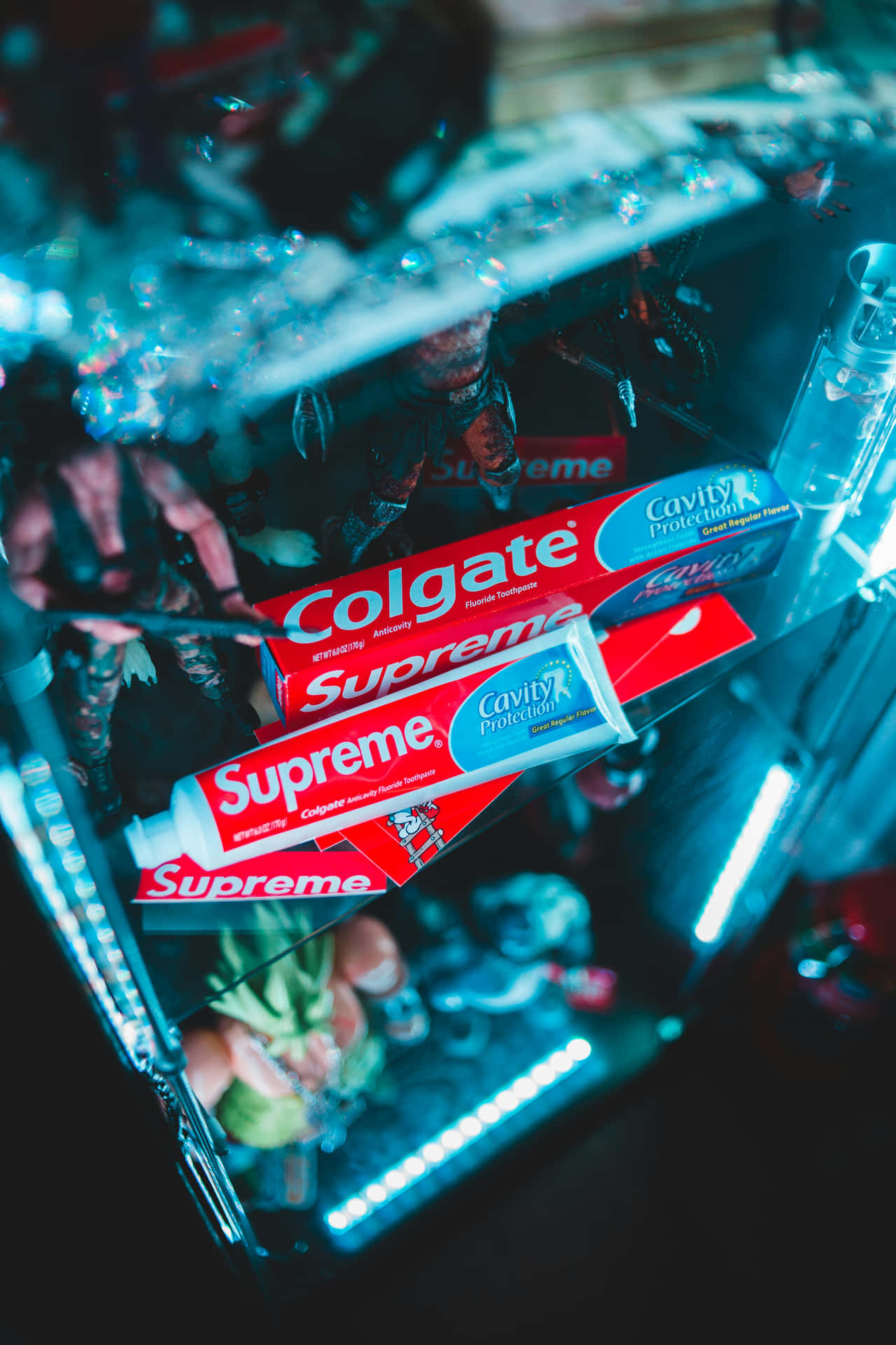  壁紙 — Colgate Supreme 牙膏管在玻璃展示櫃內被霓虹藍光照亮。