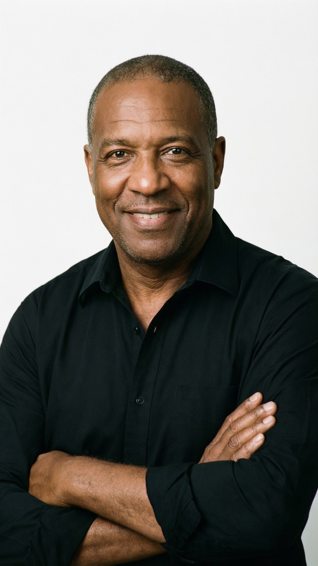 Jerry Blackwell 桌布 壁紙 — 一個自信微笑的黑襯衫男子，雙臂交叉站在純白背景前。