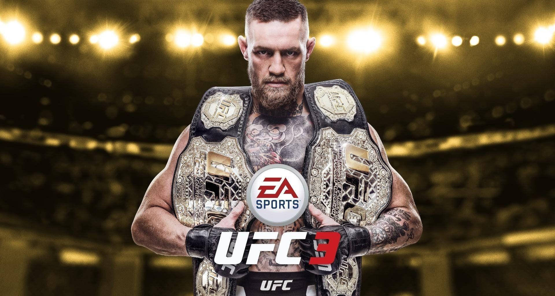 UFC 桌布 壁紙 — Conor McGregor 在明亮的場館燈光下，手持多條UFC冠軍腰帶，眼神專注。