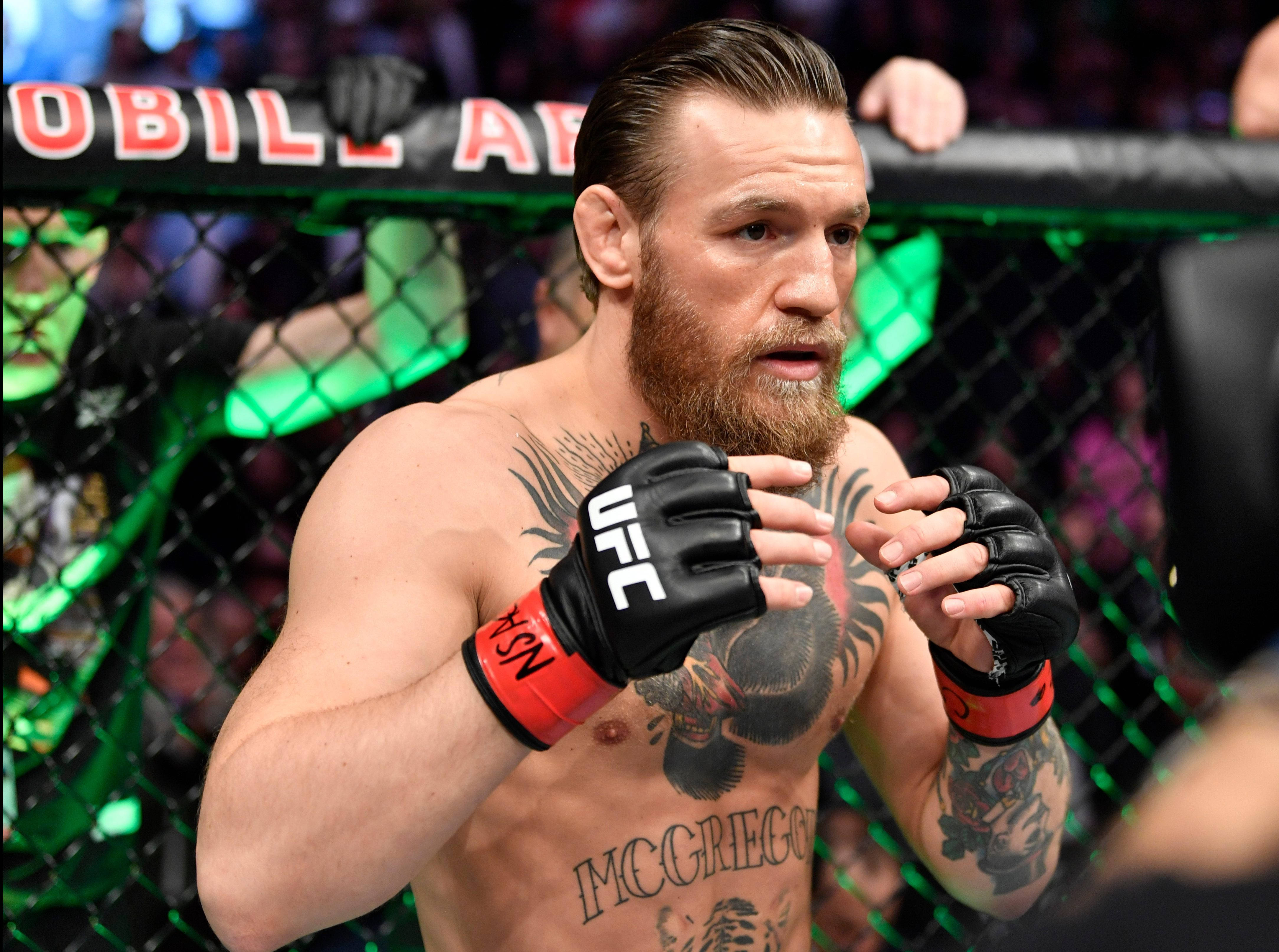 Mcgregor 桌布 壁紙 — Conor McGregor 在UFC八角籠中，綠色發光圍欄和身後人群，眼神專注。