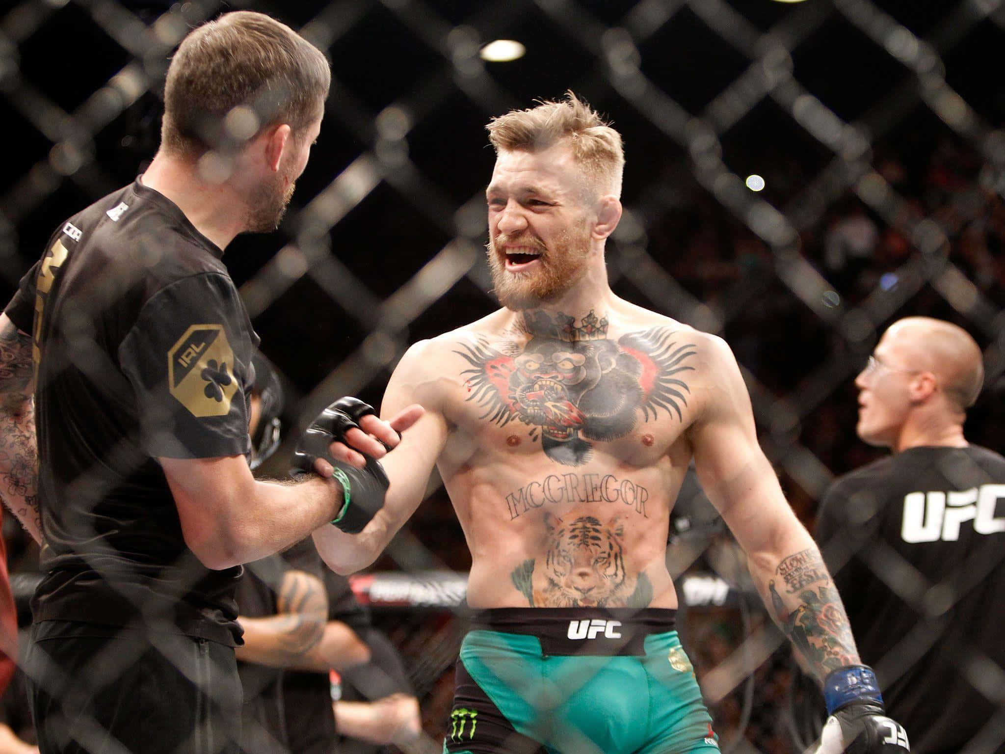 康納·麥葛雷格 桌布 壁紙 — Conor McGregor 在UFC八角籠中慶祝勝利，露出勝利的笑容和紋身上身。