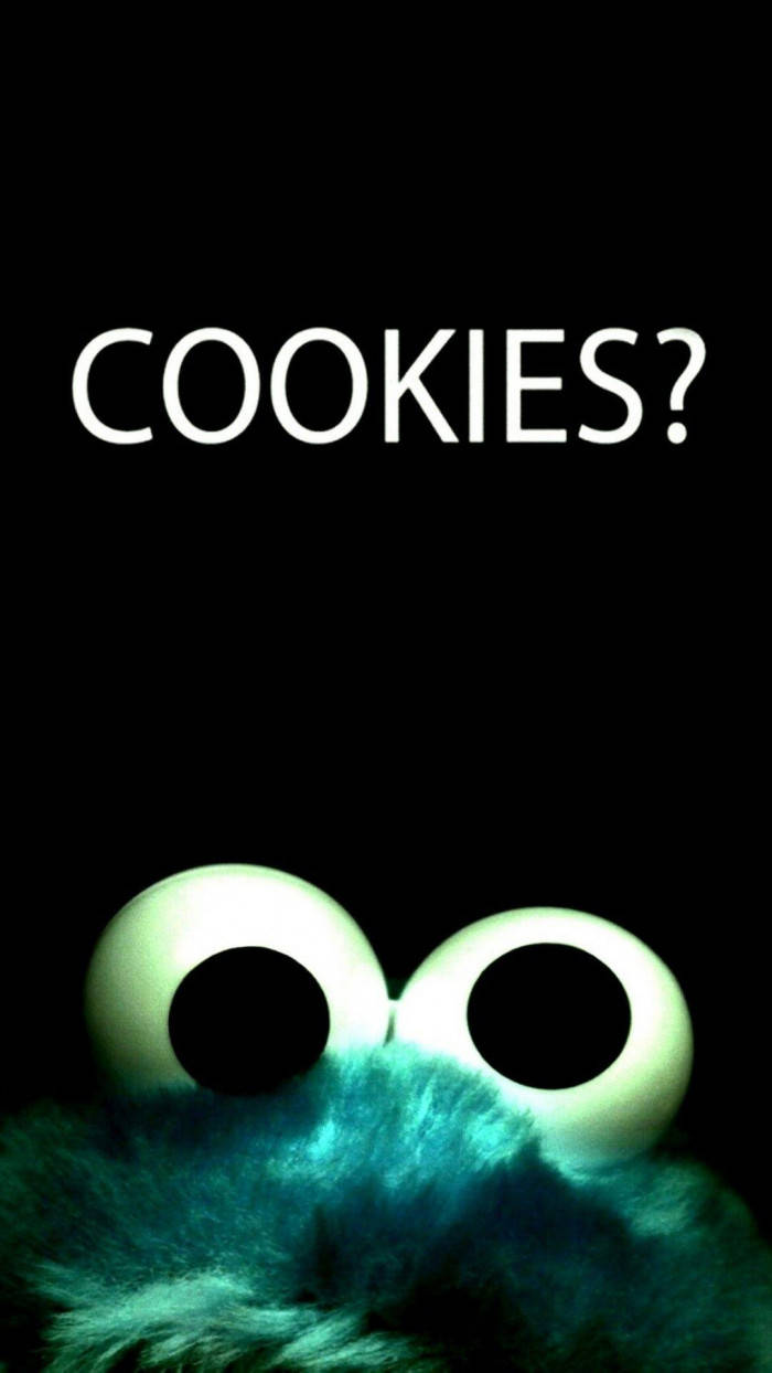 黑白 桌布 壁紙 — Cookie Monster 發光的眼睛和藍綠色毛髮的特寫，背景為黑色，並帶有白色文字 COOKIES?。