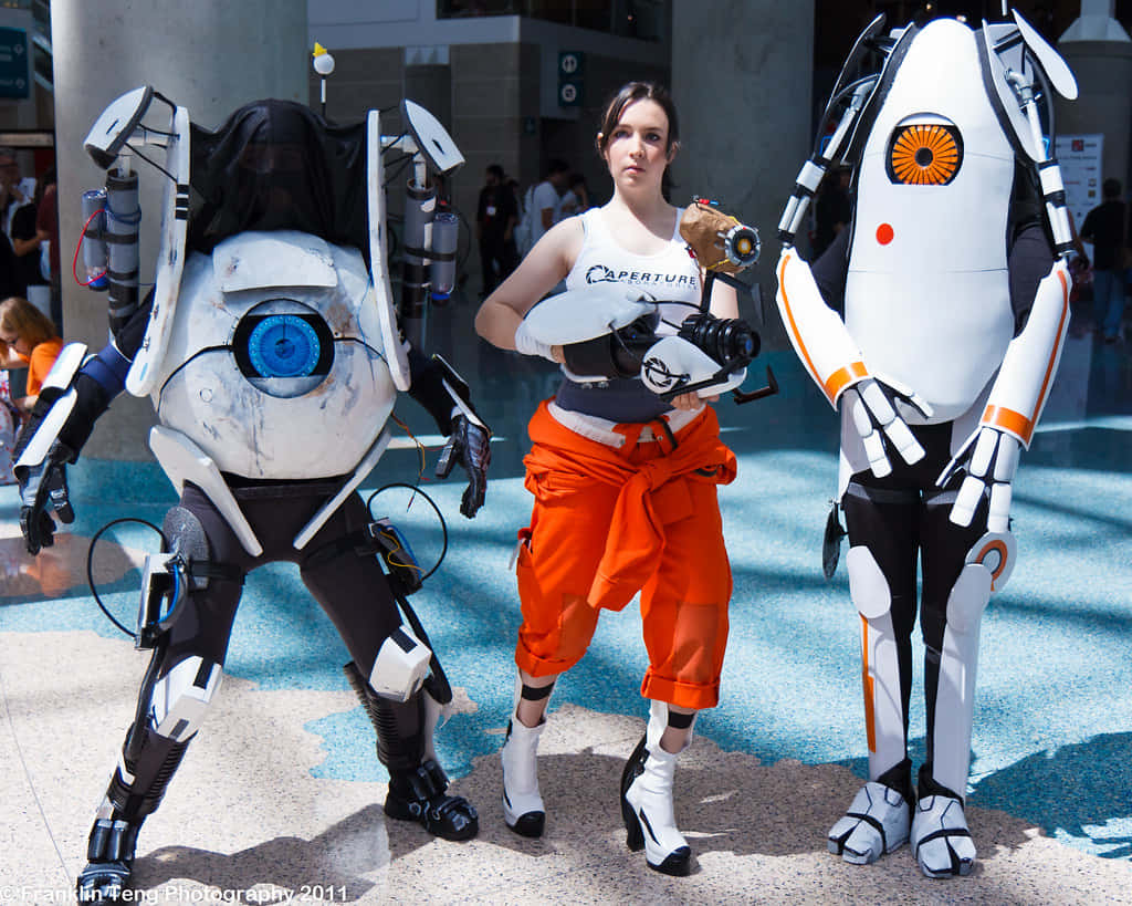 Portal Characters 桌布 壁紙 — 穿著精細 Portal 2 服裝的角色扮演者在明亮的日光下於戶外會議中擺姿勢。