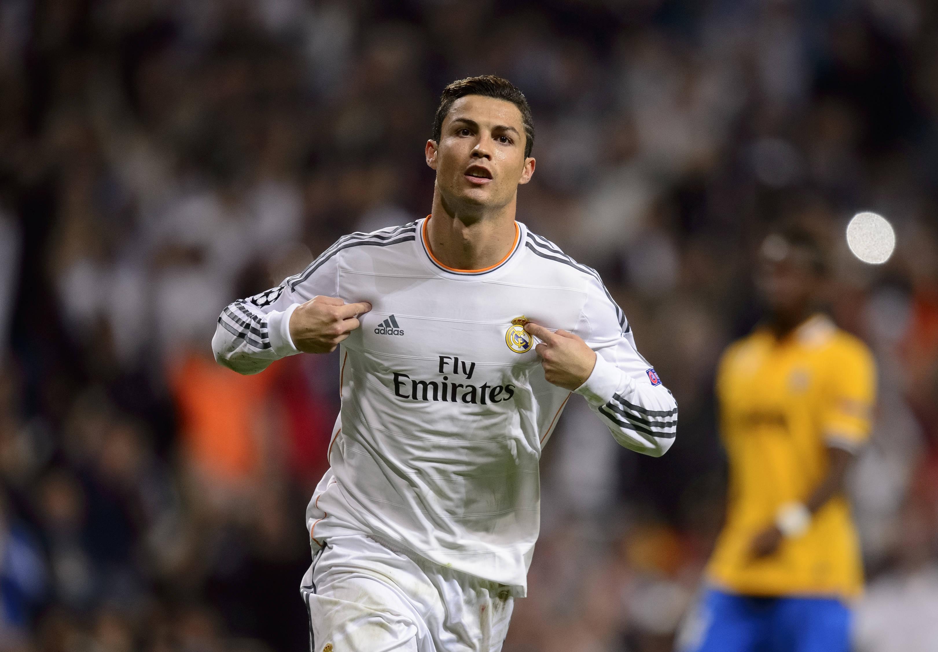 Cr7 桌布 壁紙 — Cristiano Ronaldo 身穿白色皇家馬德里球衣，在夜間足球比賽中於球場燈光下雙手放在胸前慶祝。