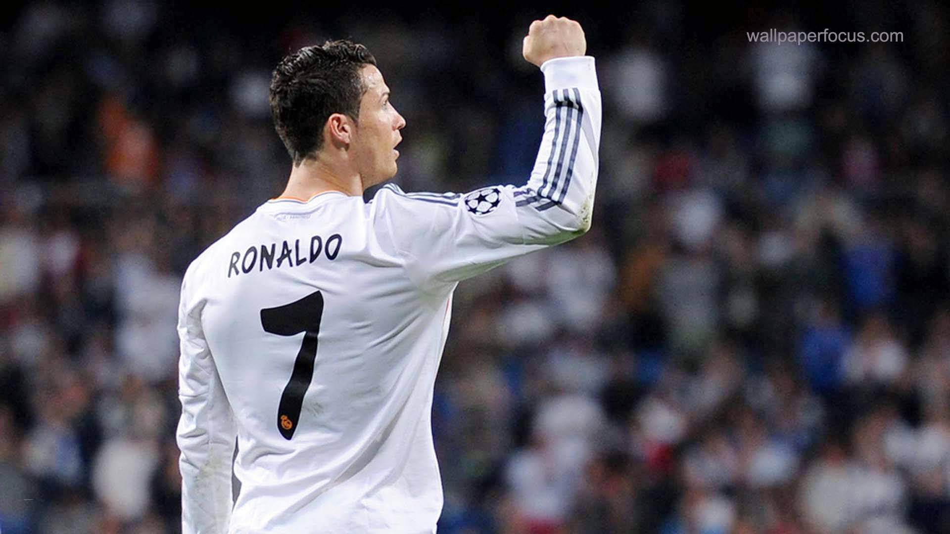 Ronaldo 桌布 壁紙 — Cristiano Ronaldo 身穿白色皇家馬德里7號球衣，在球場上向咆哮的球迷勝利地舉起拳頭。