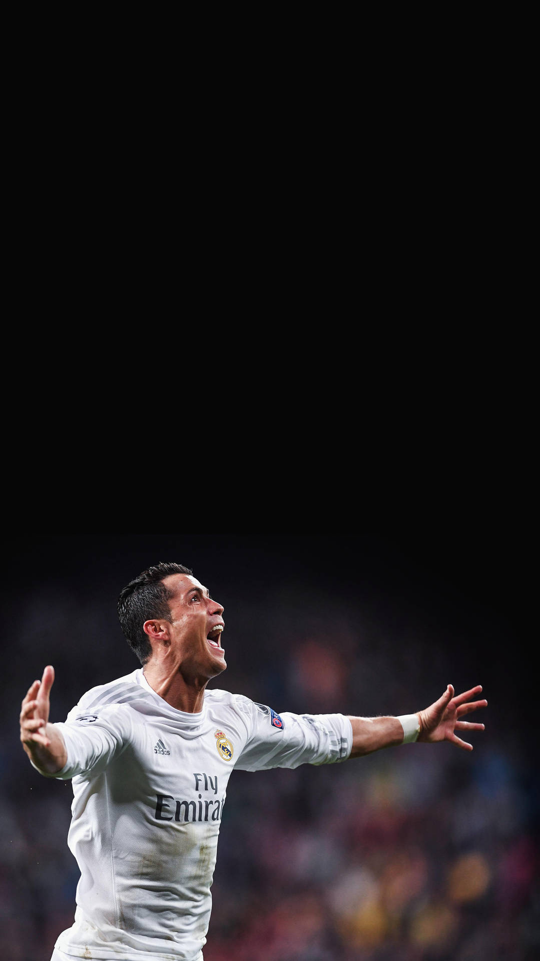 皇家馬德里 桌布 壁紙 — Cristiano Ronaldo 身穿白色皇家馬德里球衣，在黑暗的球場背景下勝利慶祝。