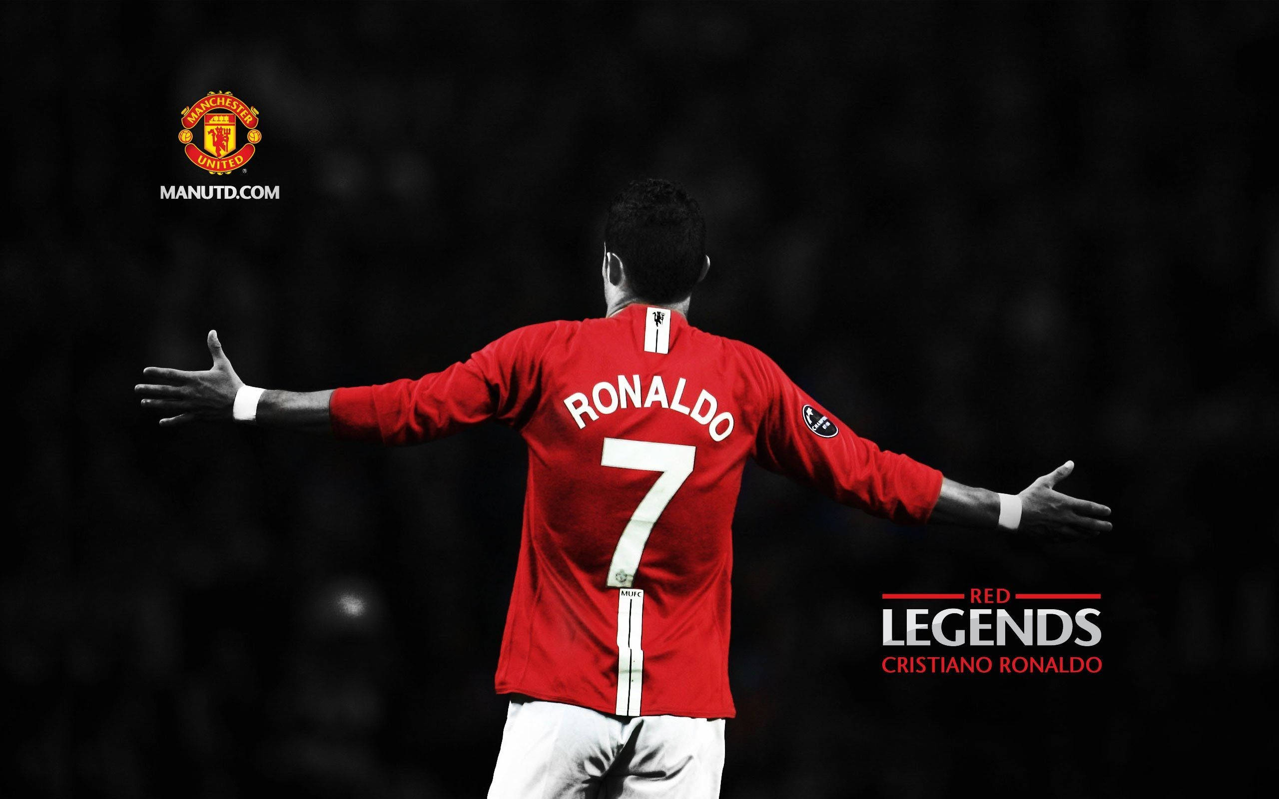 Ronaldo 桌布 壁紙 — Cristiano Ronaldo 身穿紅色曼聯球衣，雙臂張開，背景是黑暗模糊的球場。