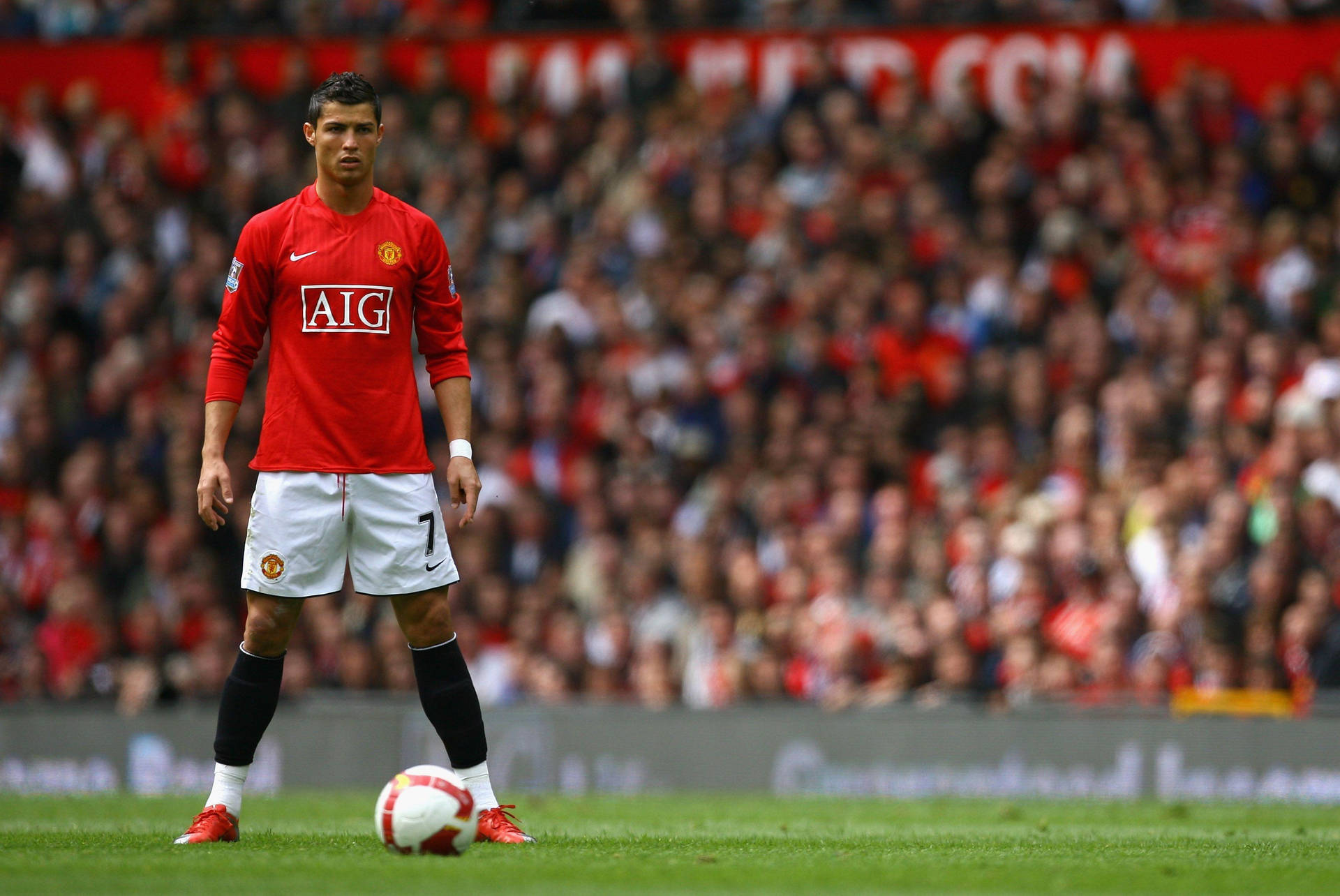 Cristiano Ronaldo 身穿紅色曼聯球衣，手持足球站在草地上。 — 克里斯蒂亞諾·羅納度 曼聯 壁紙