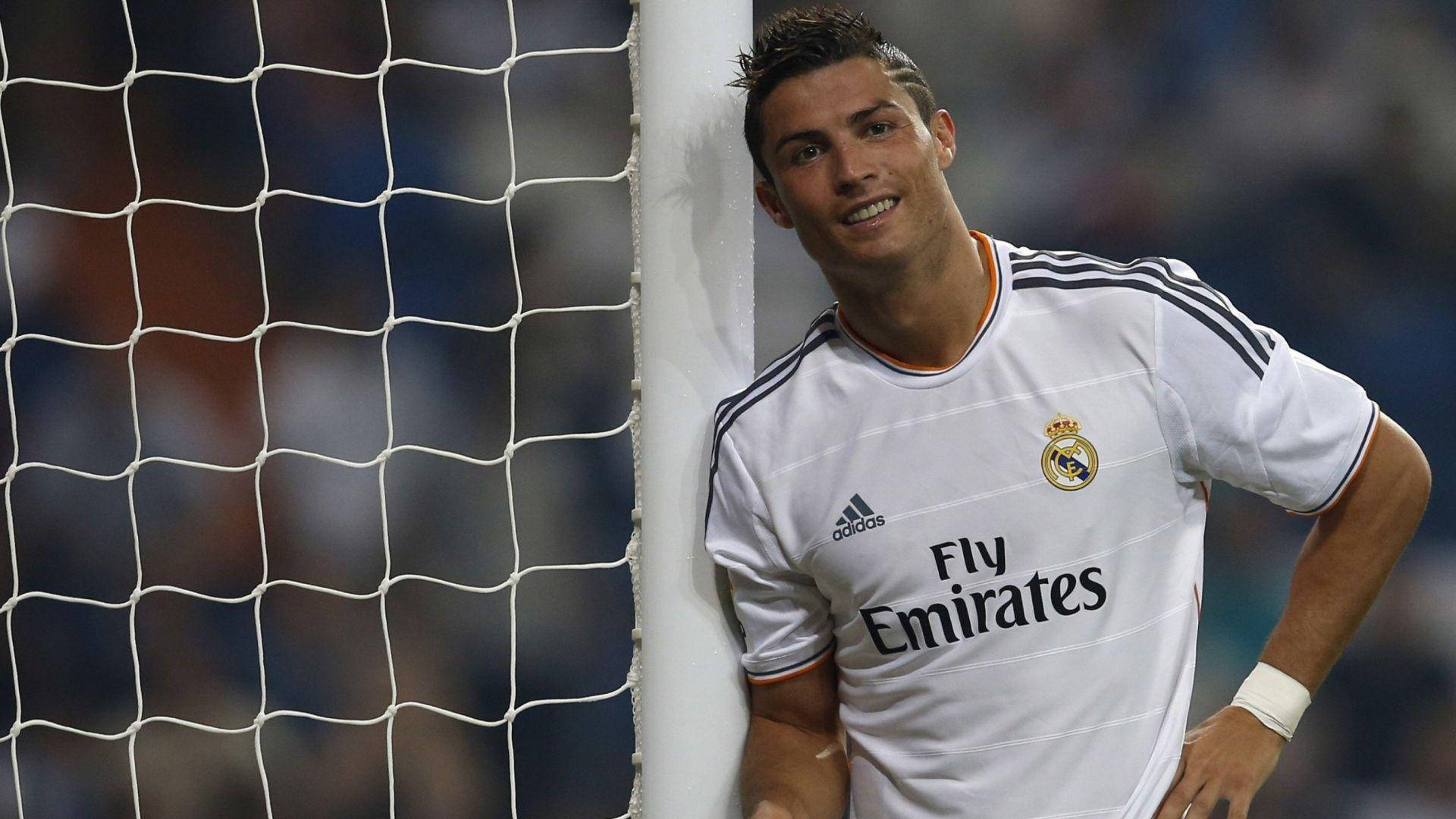 Cristiano Ronaldo 身穿皇家馬德里球衣靠在足球門柱上微笑。 — 皇家馬德里 GIF 壁紙