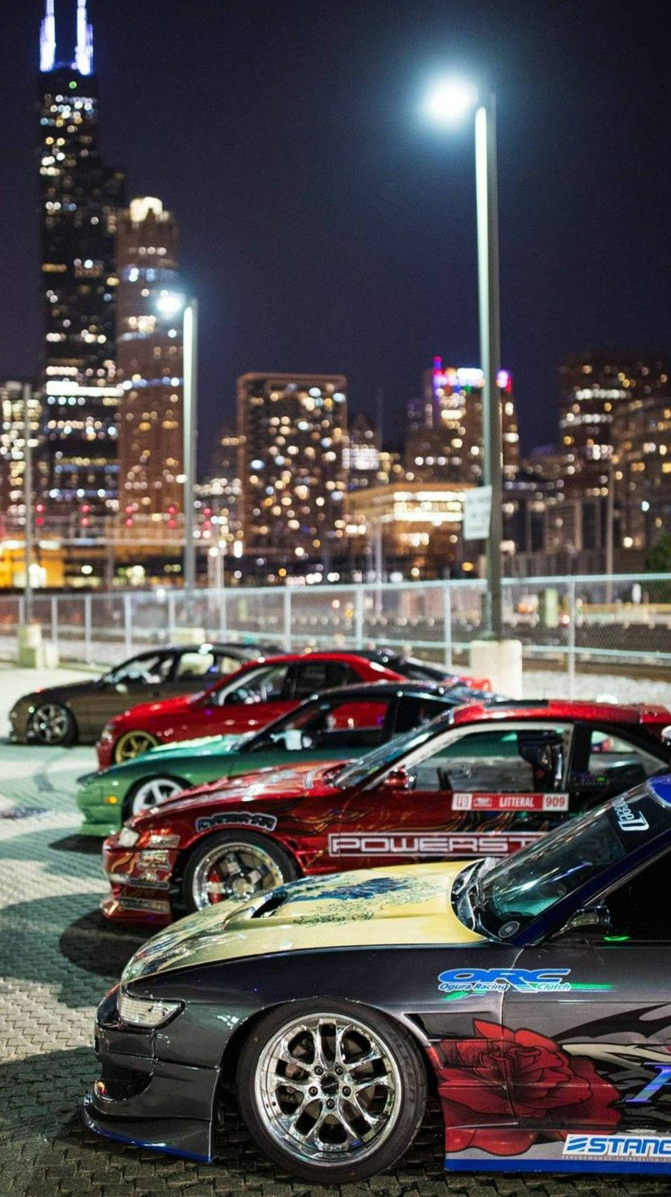 定制漂移車在夜間停放，芝加哥天際線在它們身後閃耀。 — JDM汽車 壁紙
