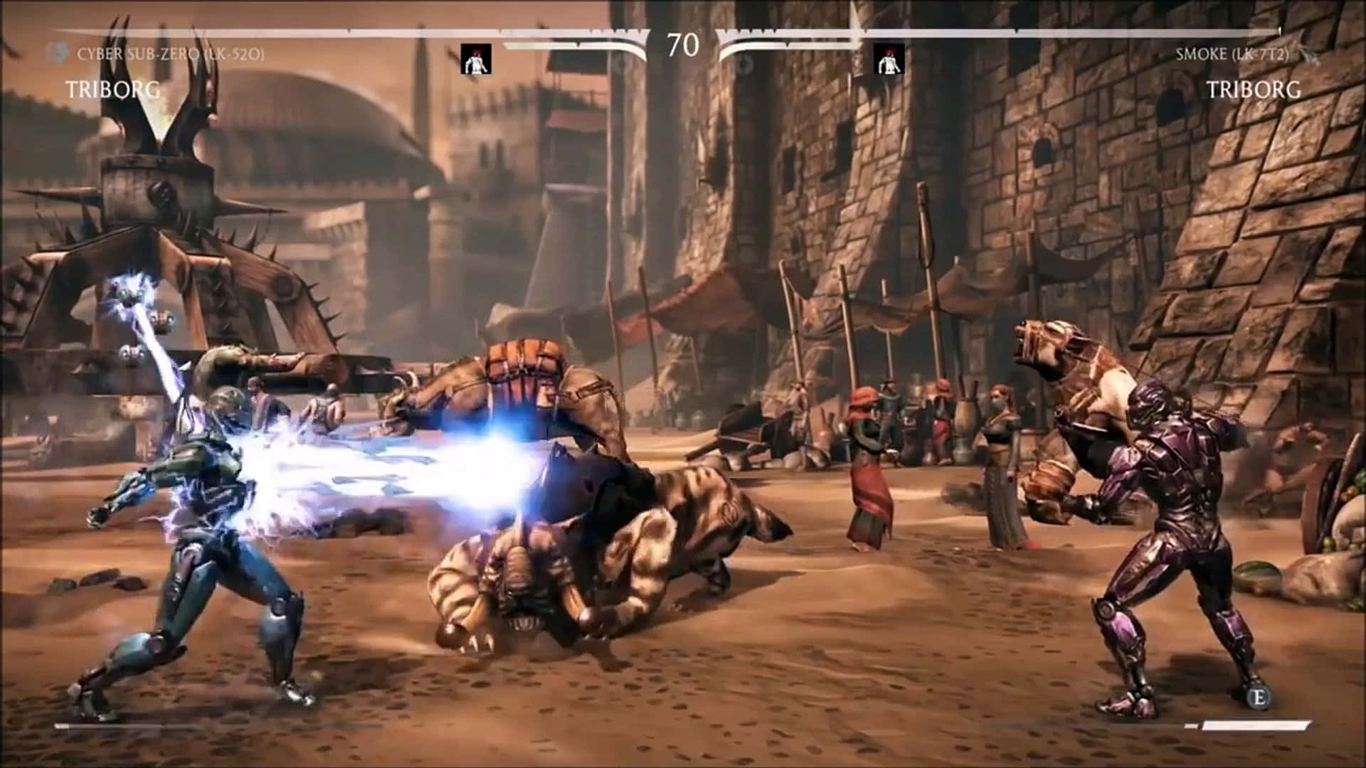 Mortal Kombat Triborg 桌布 壁紙 — Cyber Sub-Zero 在塵土飛揚的中世紀競技場中，向一個怪物般的對手釋放出發光的藍色能量衝擊波。