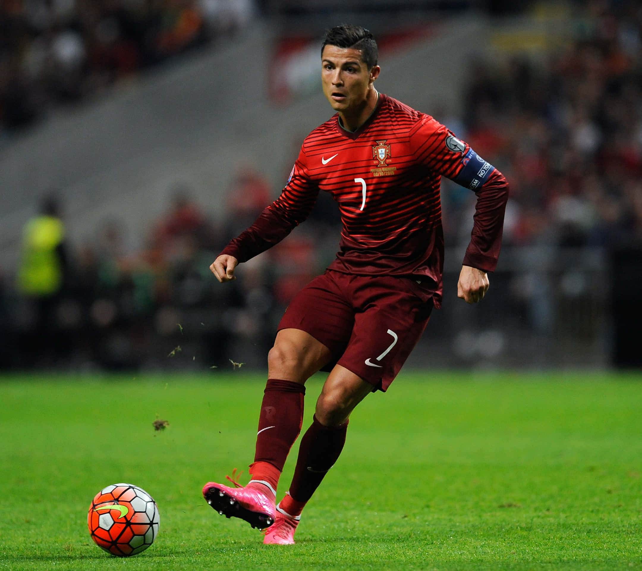 Ronaldo 桌布 壁紙 — C羅身穿紅色葡萄牙球衣，在球場燈光下於充滿活力的綠色草地上盤球。