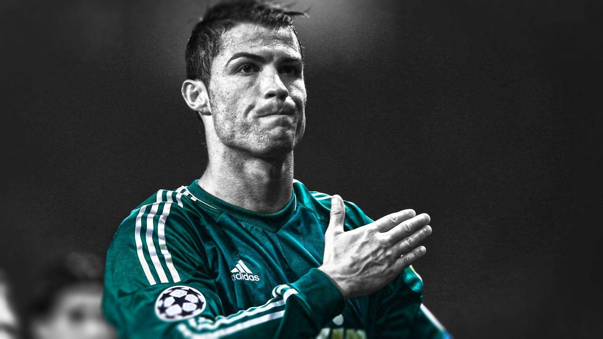 Ronaldo 桌布 壁紙 — C羅身穿綠色球衣，在黑暗模糊的球場背景下拍手，表情專注而強烈。