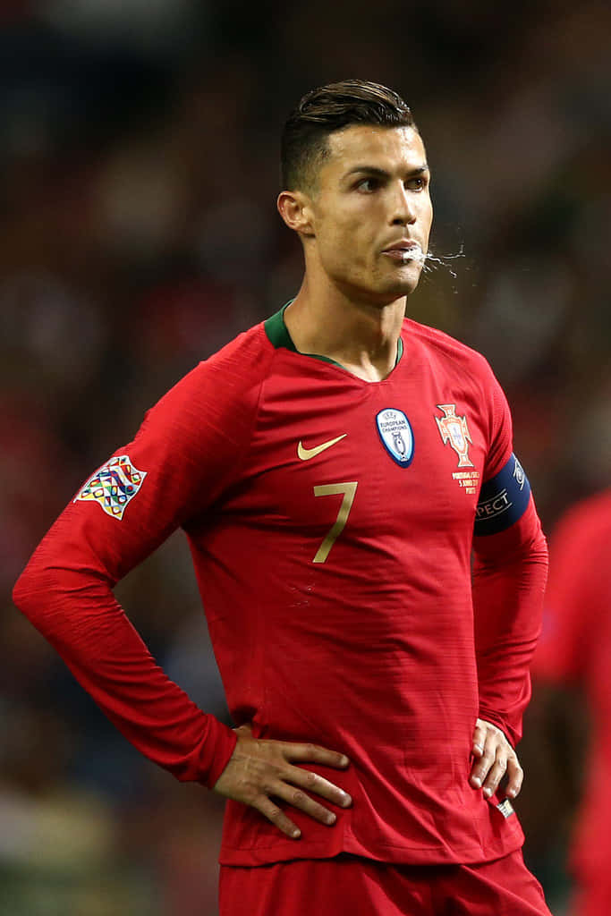 Ronaldo 桌布 壁紙 — C羅身穿葡萄牙紅色7號球衣，在球場燈光下的足球比賽中雙手叉腰站立。