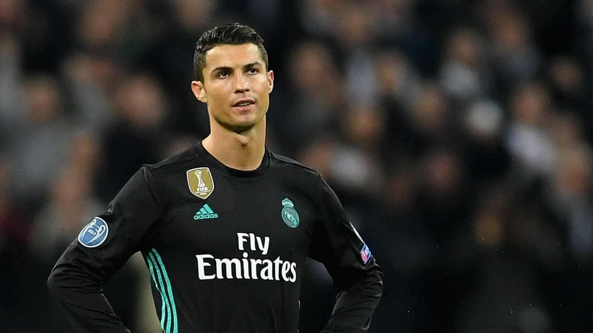 Ronaldo 桌布 壁紙 — C羅身穿黑色皇家馬德里球衣，在球場燈光下專注地站在場上，背後是模糊的人群。
