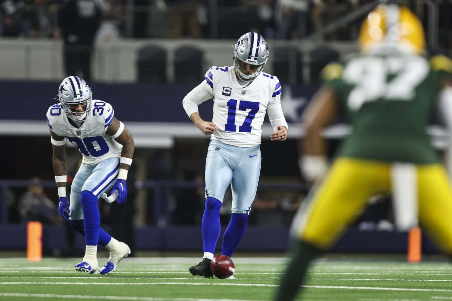  壁紙 — 達拉斯牛仔隊四分衛達克·普雷斯科特在體育場燈光下準備在夜間NFL比賽中棄踢球。