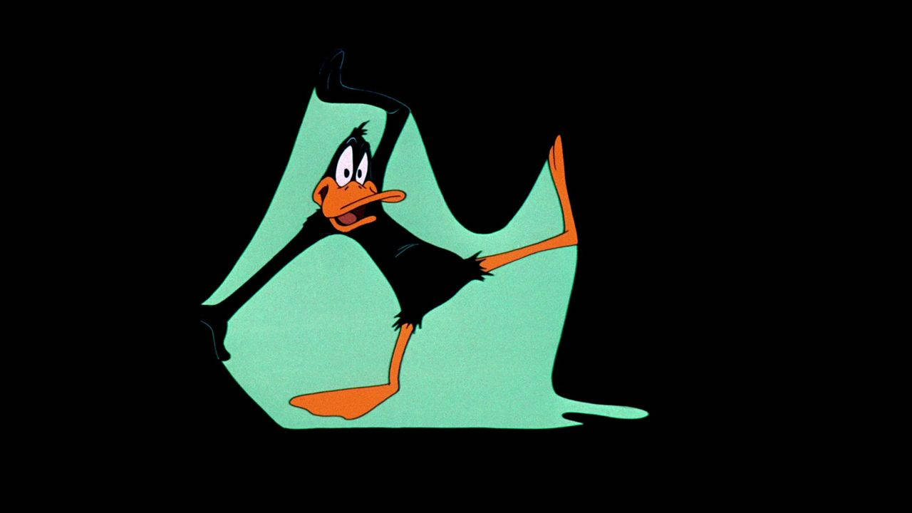 達菲鴨 桌布 壁紙 — Daffy Duck 在一個青色液體水坑中，舉起手臂，雙腿張開，背景為黑色。